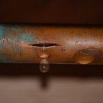Water leak from damaged copper pipe with visible droplets, illustrating the need for prompt leak detection and repair services by Jersey Trenchless LLC in Bound Brook, NJ.